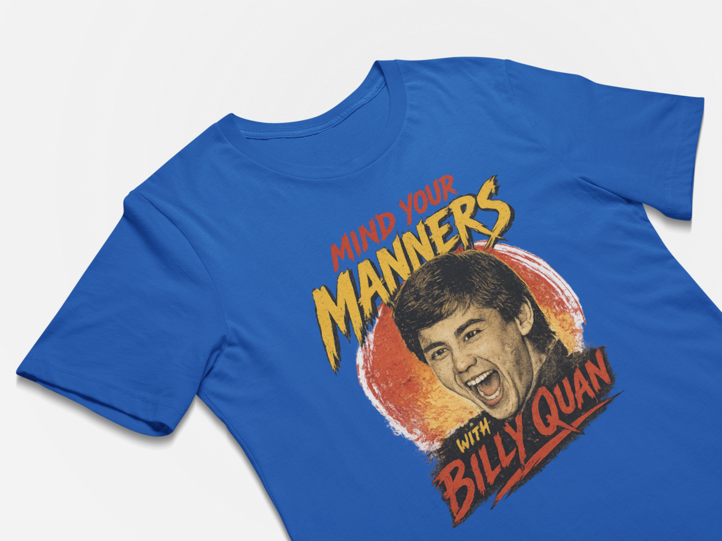 Blue t-shirt with a graphic of a man's face and text 'Mind your manners with Billy Quan' on a white background