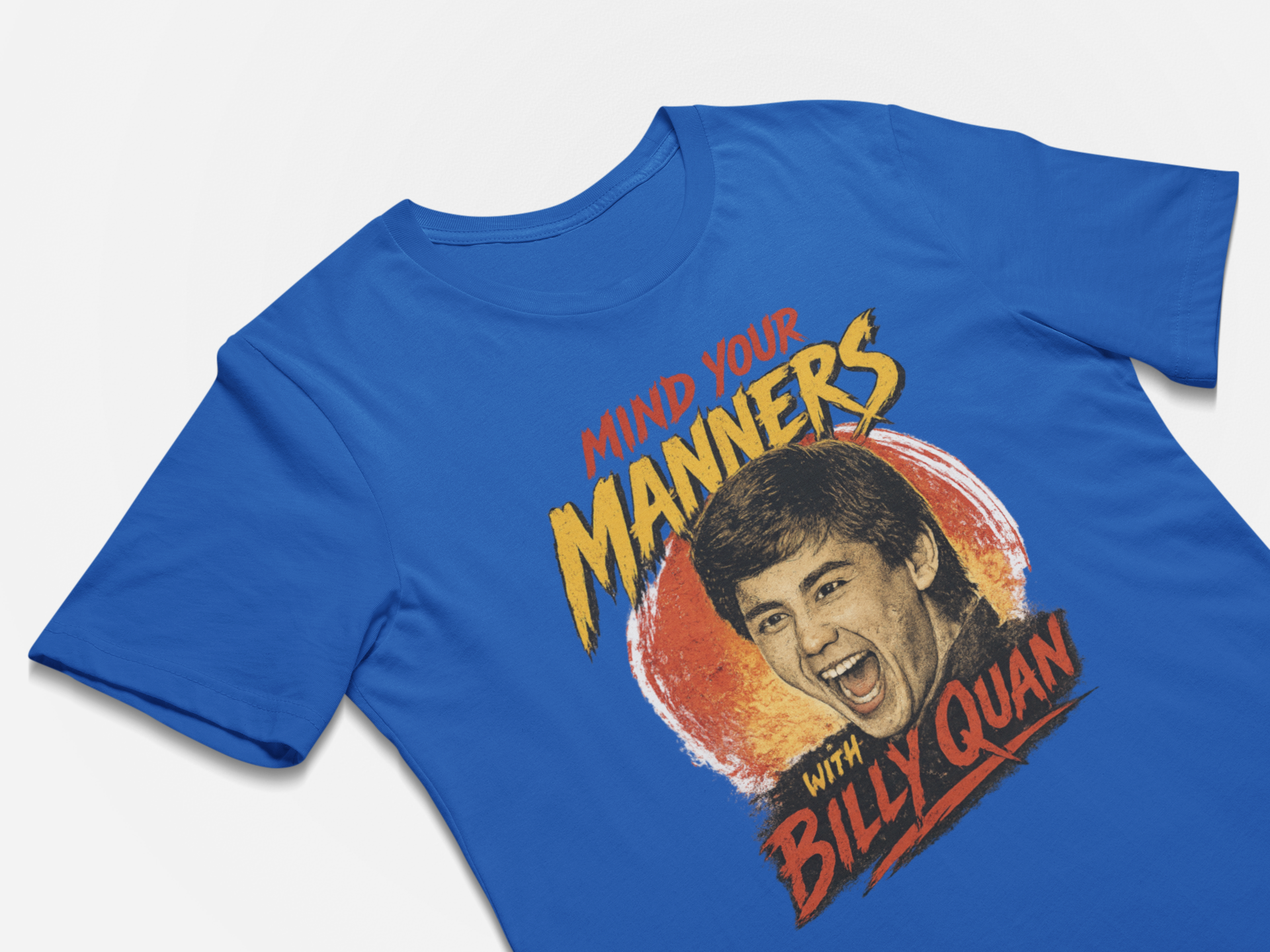 Blue t-shirt with a graphic of a man's face and text 'Mind your manners with Billy Quan' on a white background