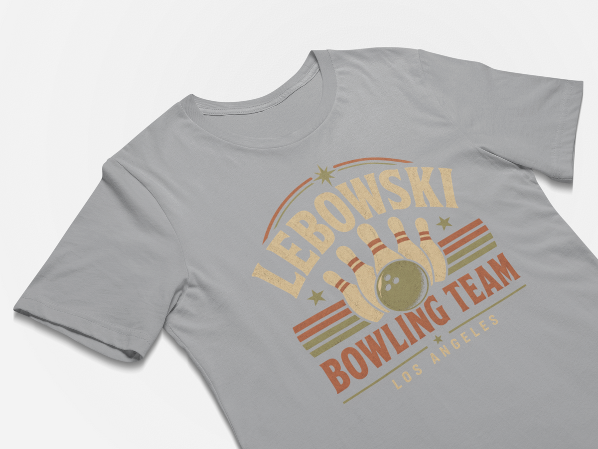 A light gray crewneck t-shirt featuring a retro bowling graphic with the text 'LEBOWSKI BOWLING TEAM LOS ANGELES' in beige and orange tones, displayed on a clean white background.