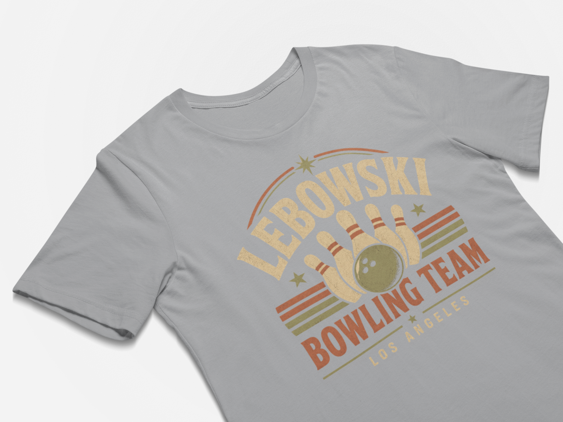 A light gray crewneck t-shirt featuring a retro bowling graphic with the text 'LEBOWSKI BOWLING TEAM LOS ANGELES' in beige and orange tones, displayed on a clean white background.