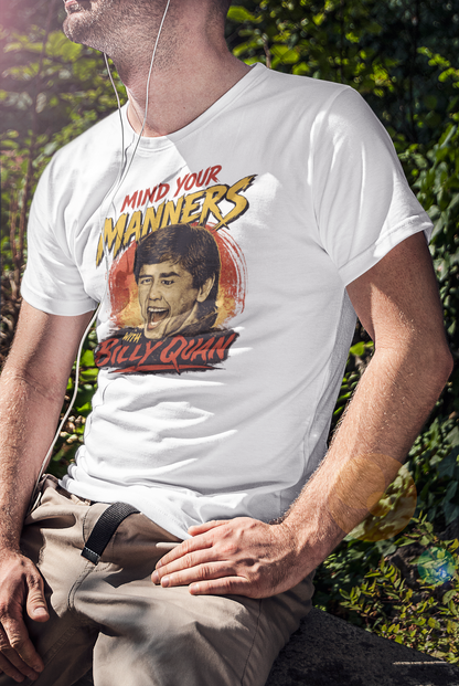 Person wearing a white t-shirt with a graphic design featuring a portrait and text, sitting outdoors.